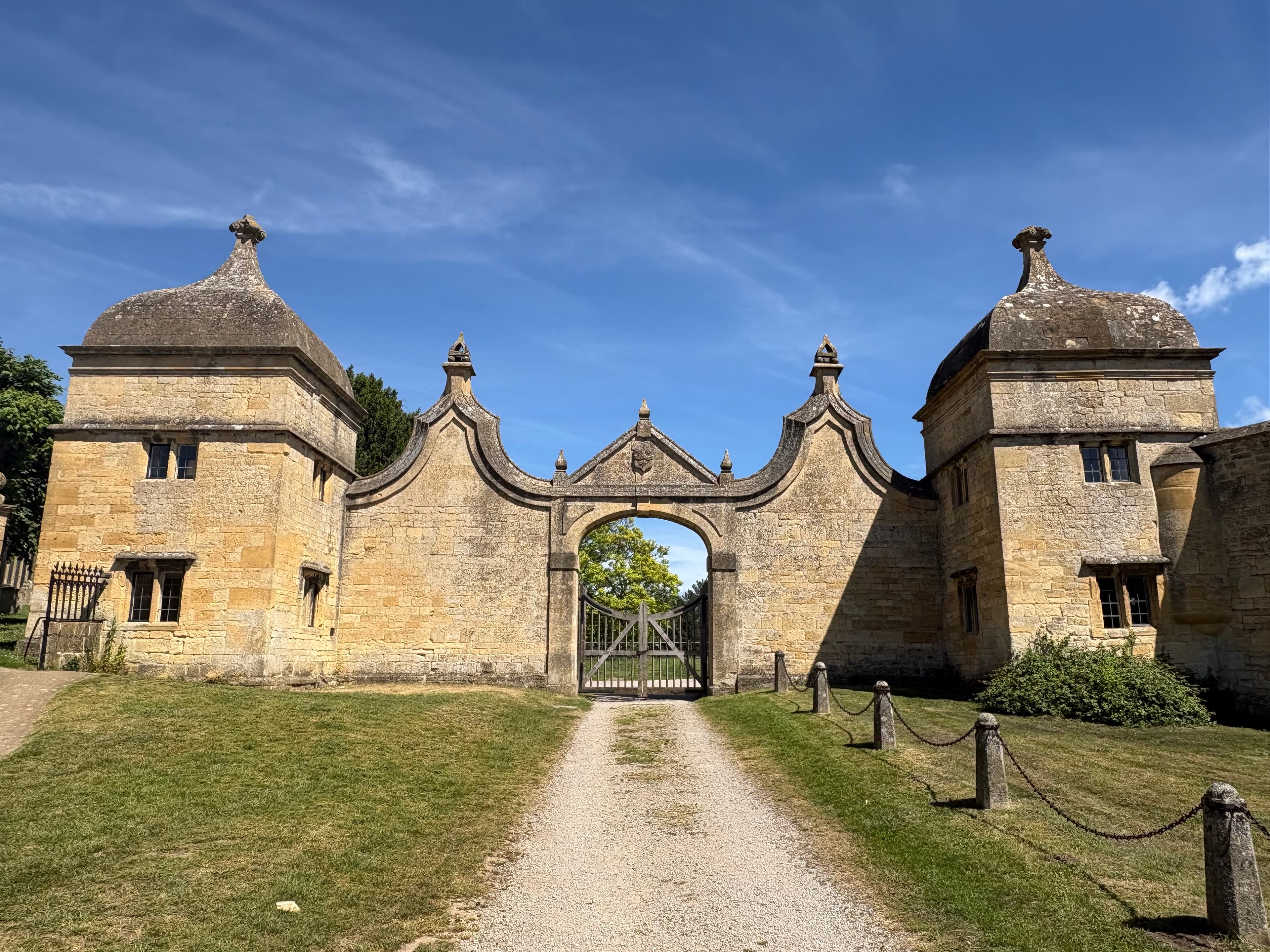 The pair of 17th-century Jacobean gatehouses at the entrance to the Court Barn site, framing a central arched gateway