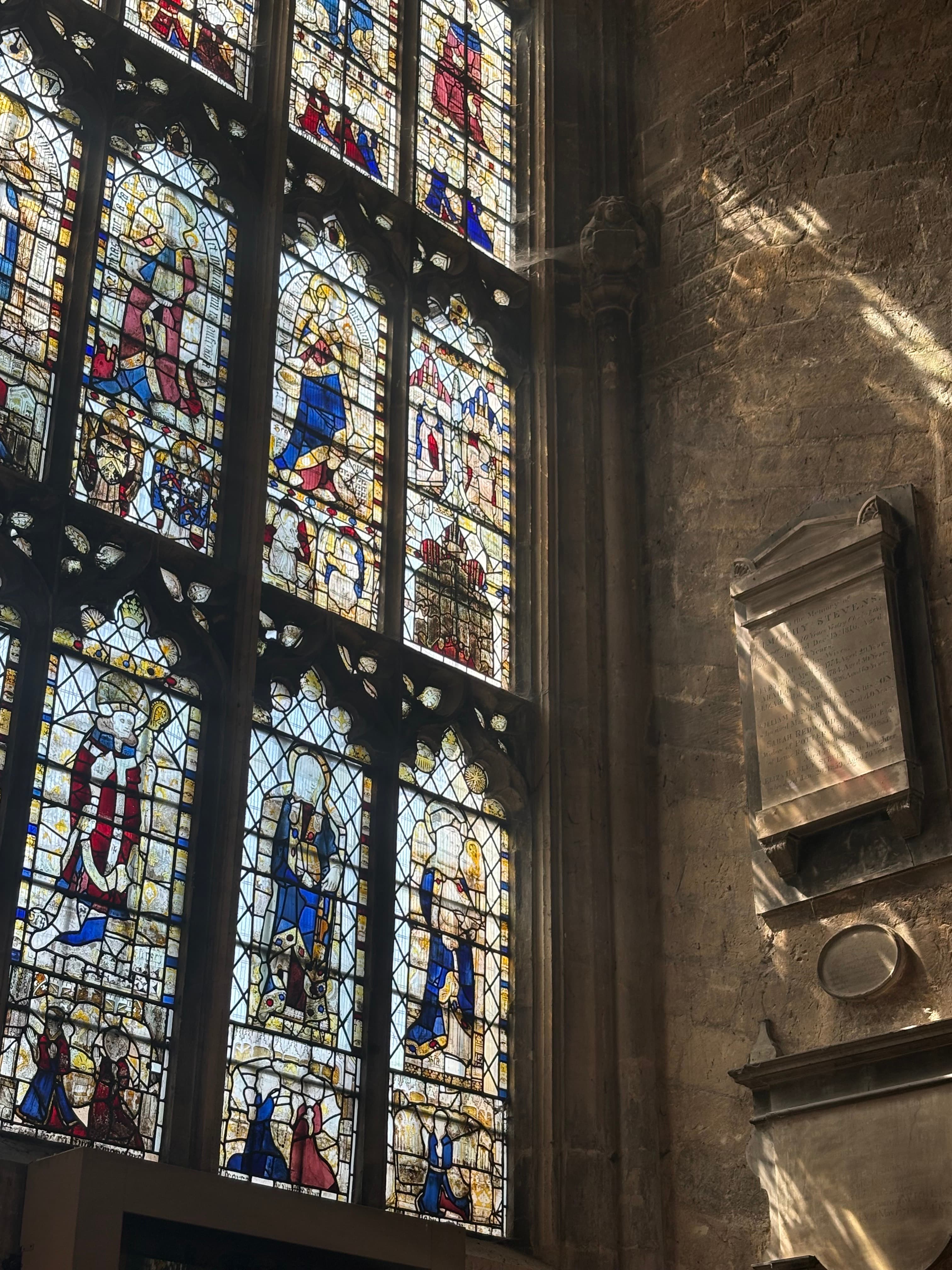 Medieval stained-glass panels with iron framework — figurative scenes in deep colour