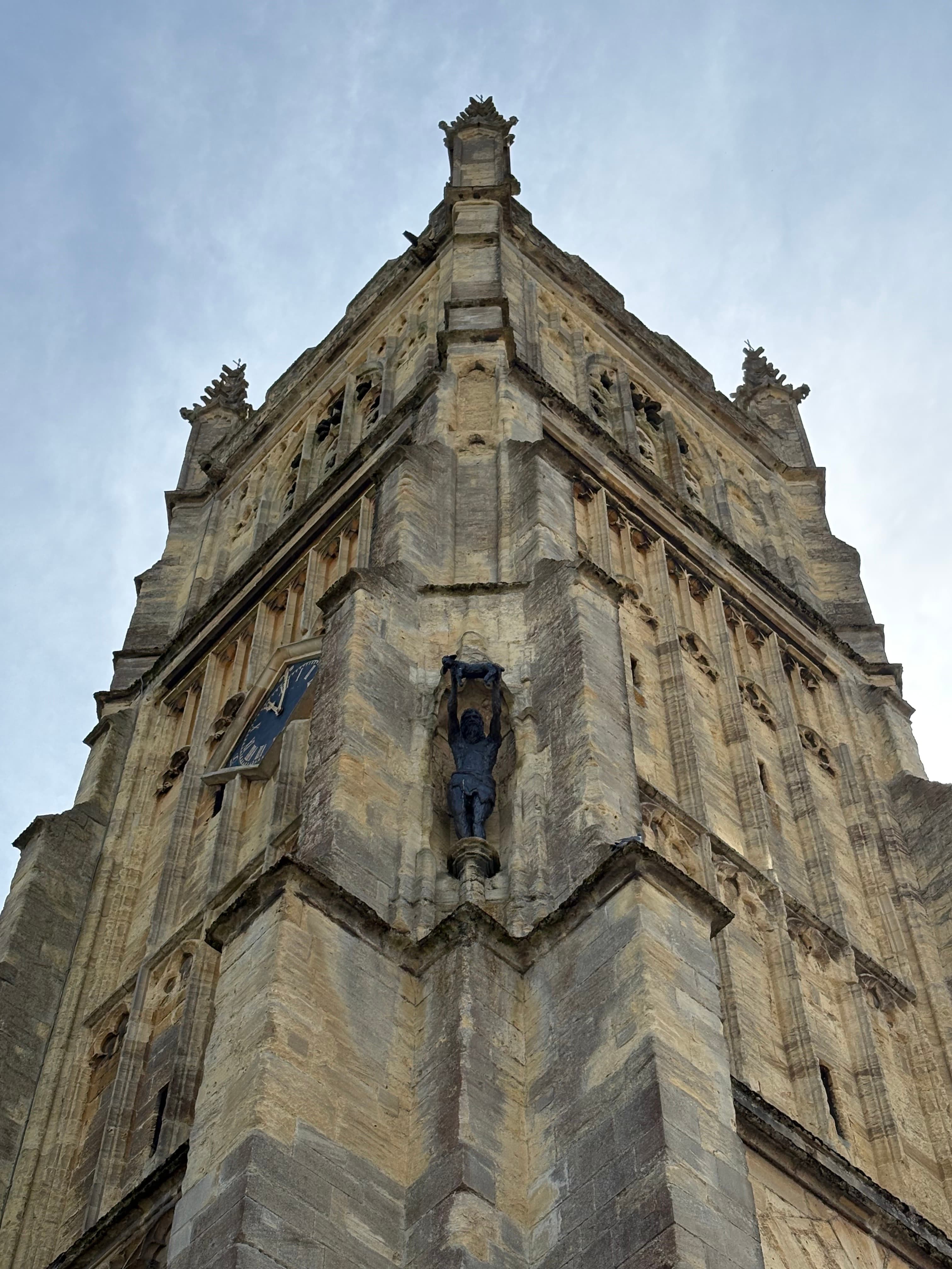 Carved statue niche set into the tower wall, with the spire rising above