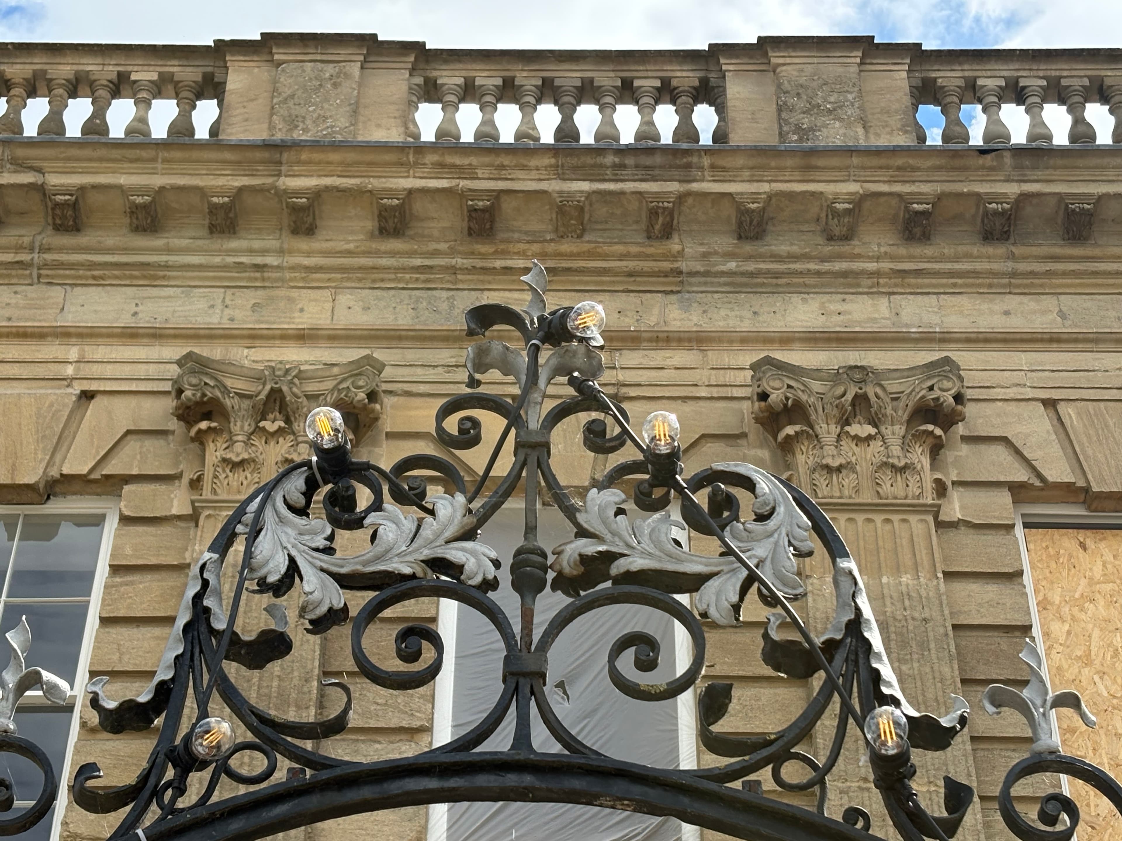 Wrought-iron gates with carved Corinthian capitals on a side street off the high street
