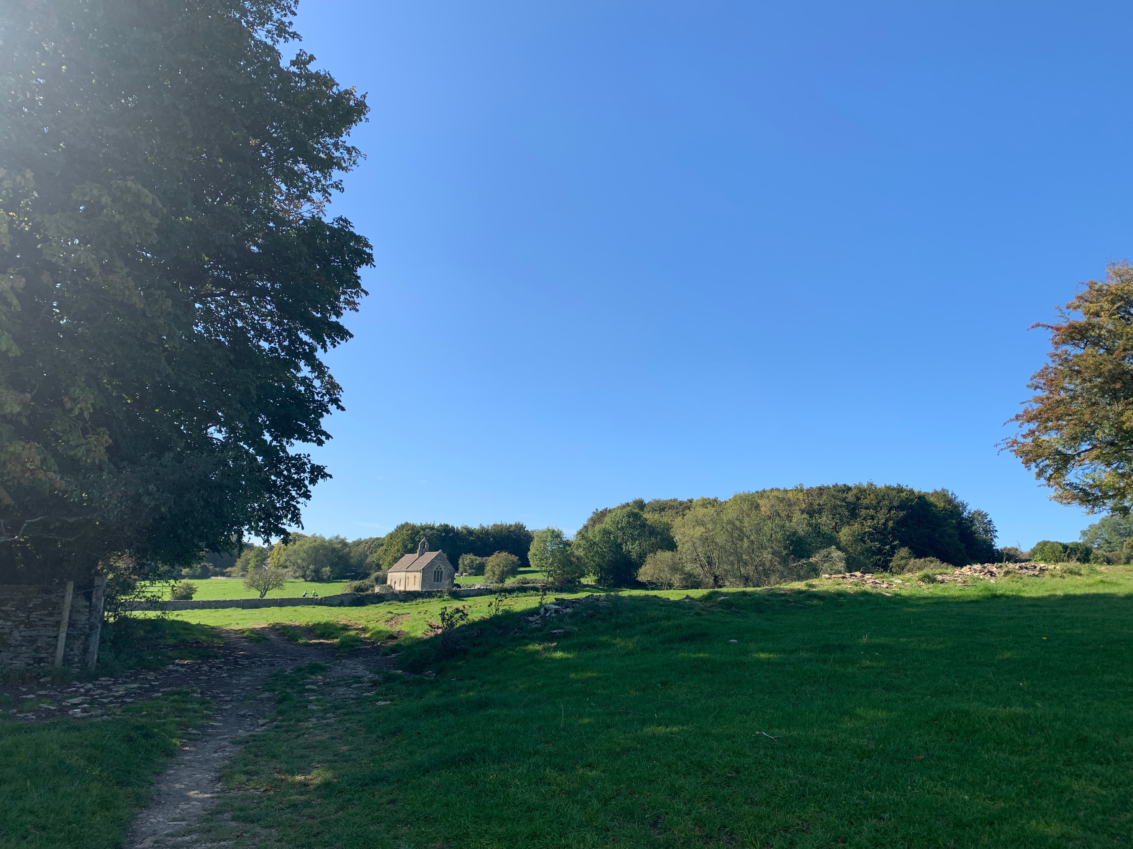 Approaching St Oswald's, Widford, on the footpath from Burford — the isolated church visible across the meadow on a clear afternoon