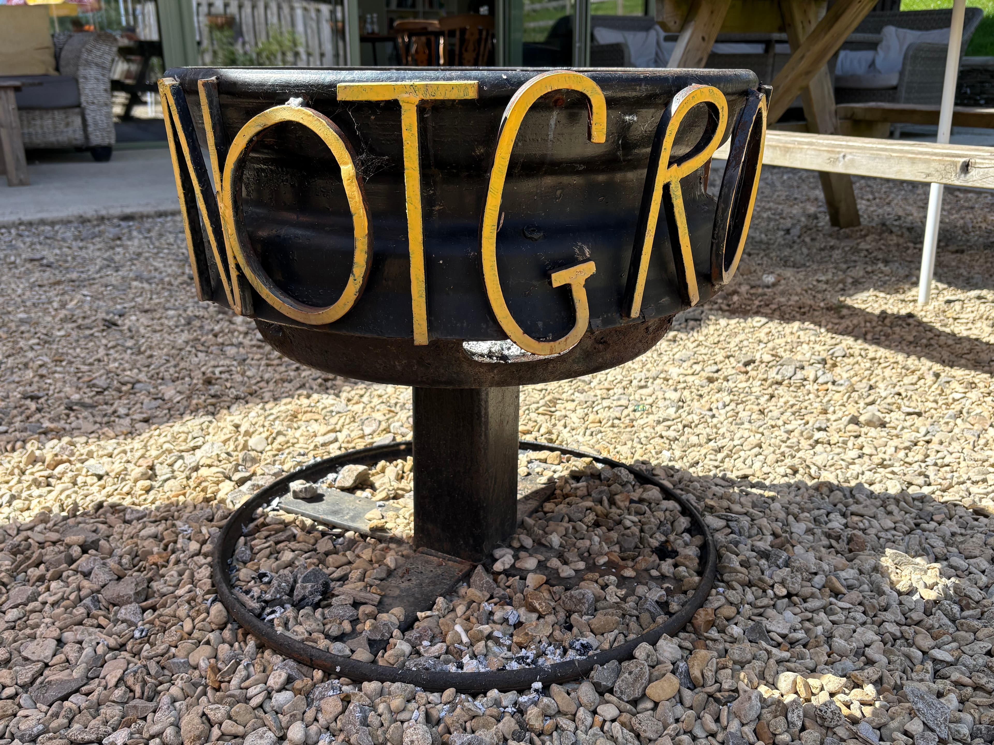 The Notgrove fire pit — letters spelling 'NOTGROVE' cut into the metal bowl
