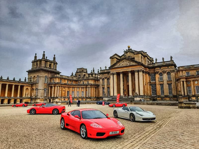 Classic Ferraris drawn up in the Great Court at Blenheim Palace, beneath the baroque facade by Vanbrugh and Hawksmoor