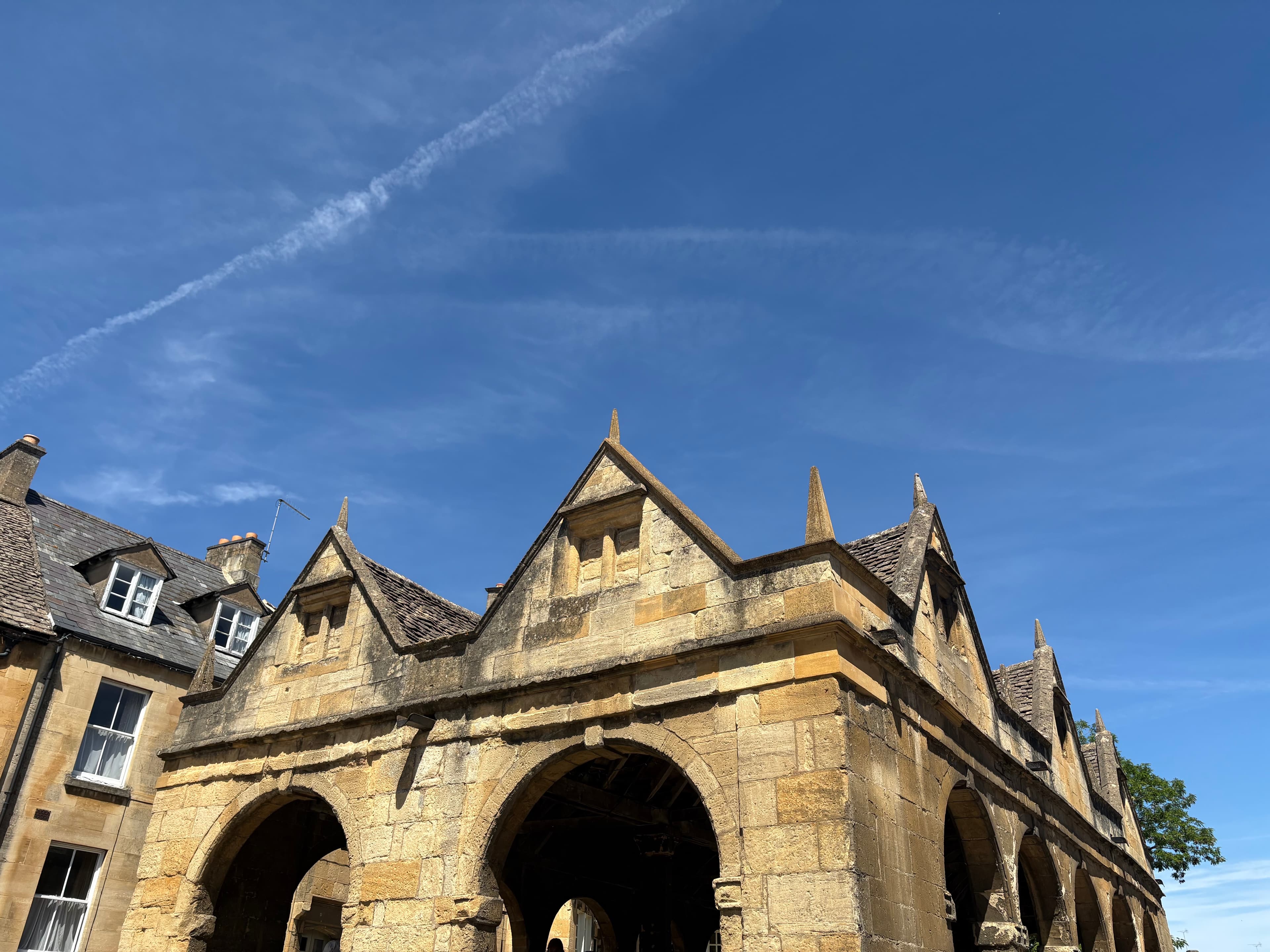 Looking up at the Market Hall's row of gables against a streaked blue sky