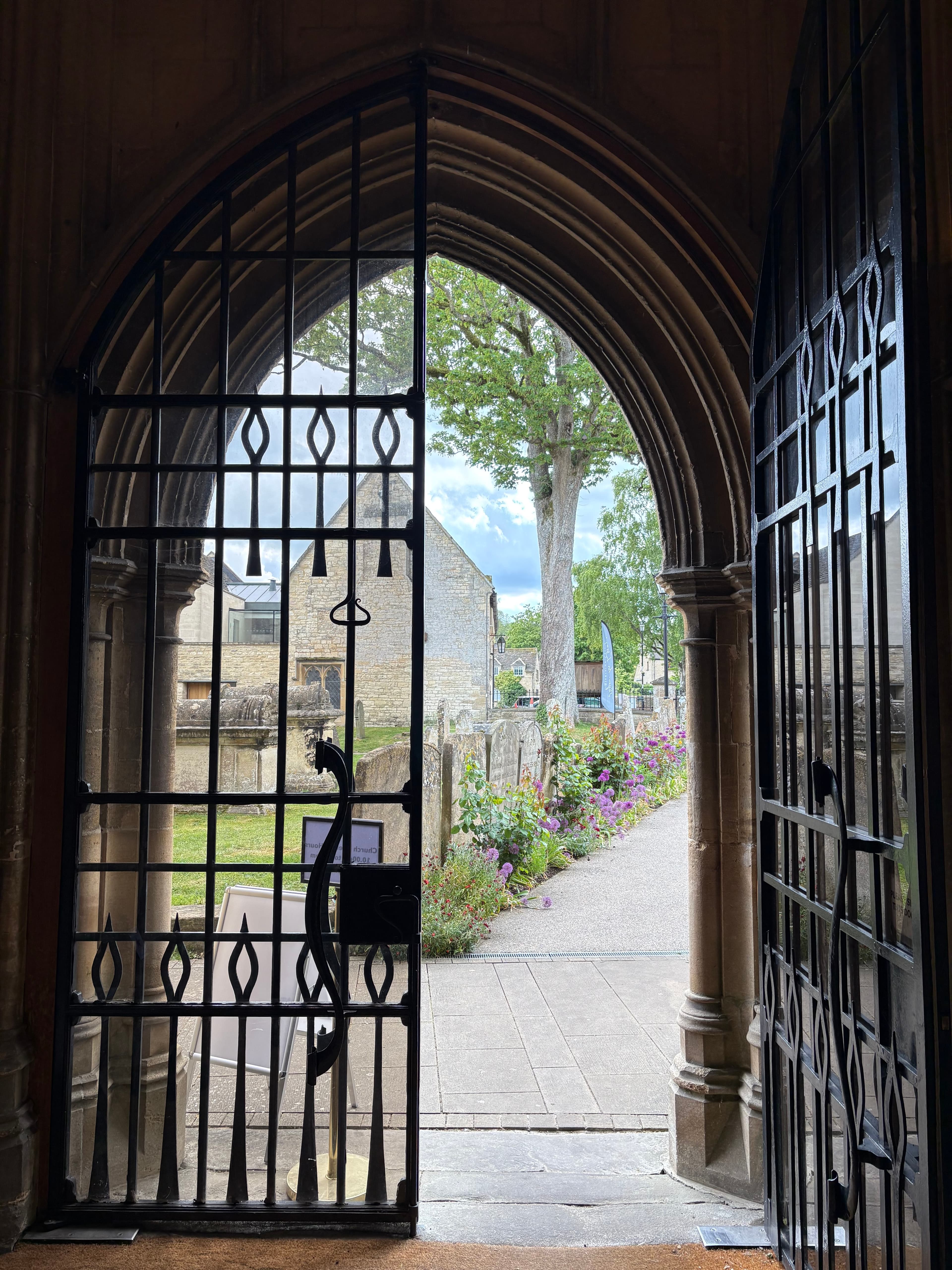 Looking out through an iron gate to the churchyard beyond