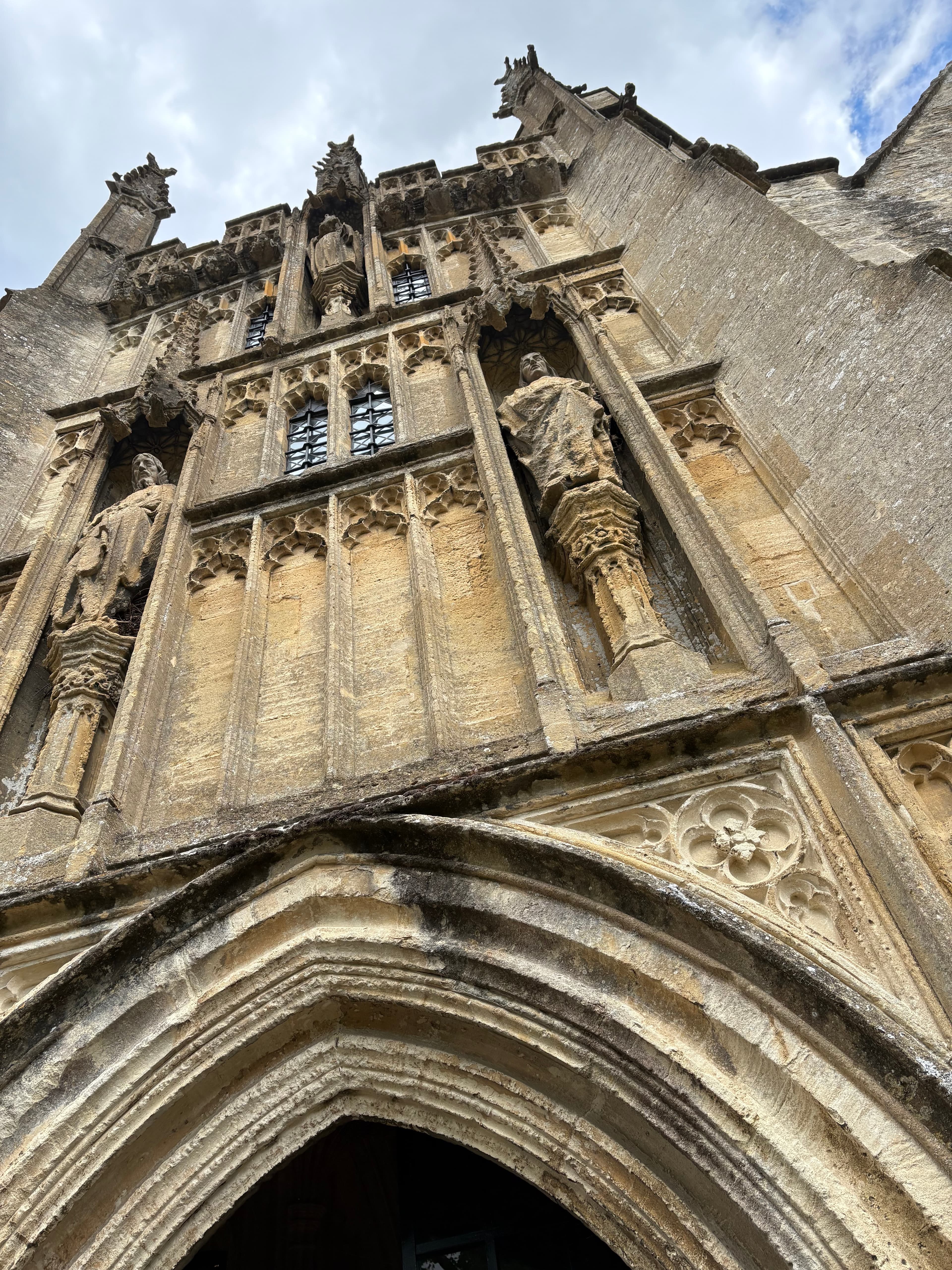 Carved gargoyles and buttressed pinnacles on the tower of St John the Baptist