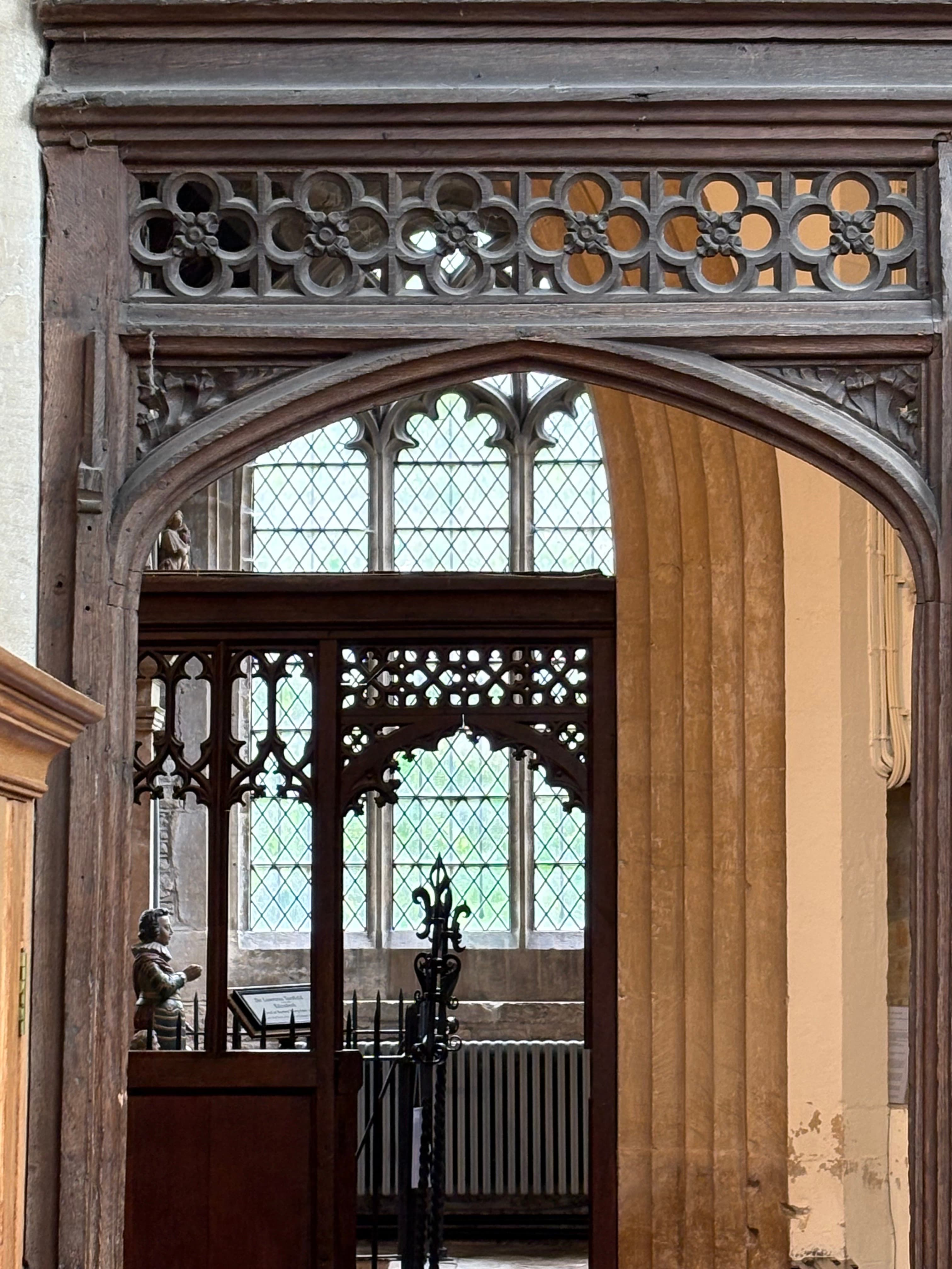 Detail of the carved oak screen — quatrefoil tracery and turned spindles