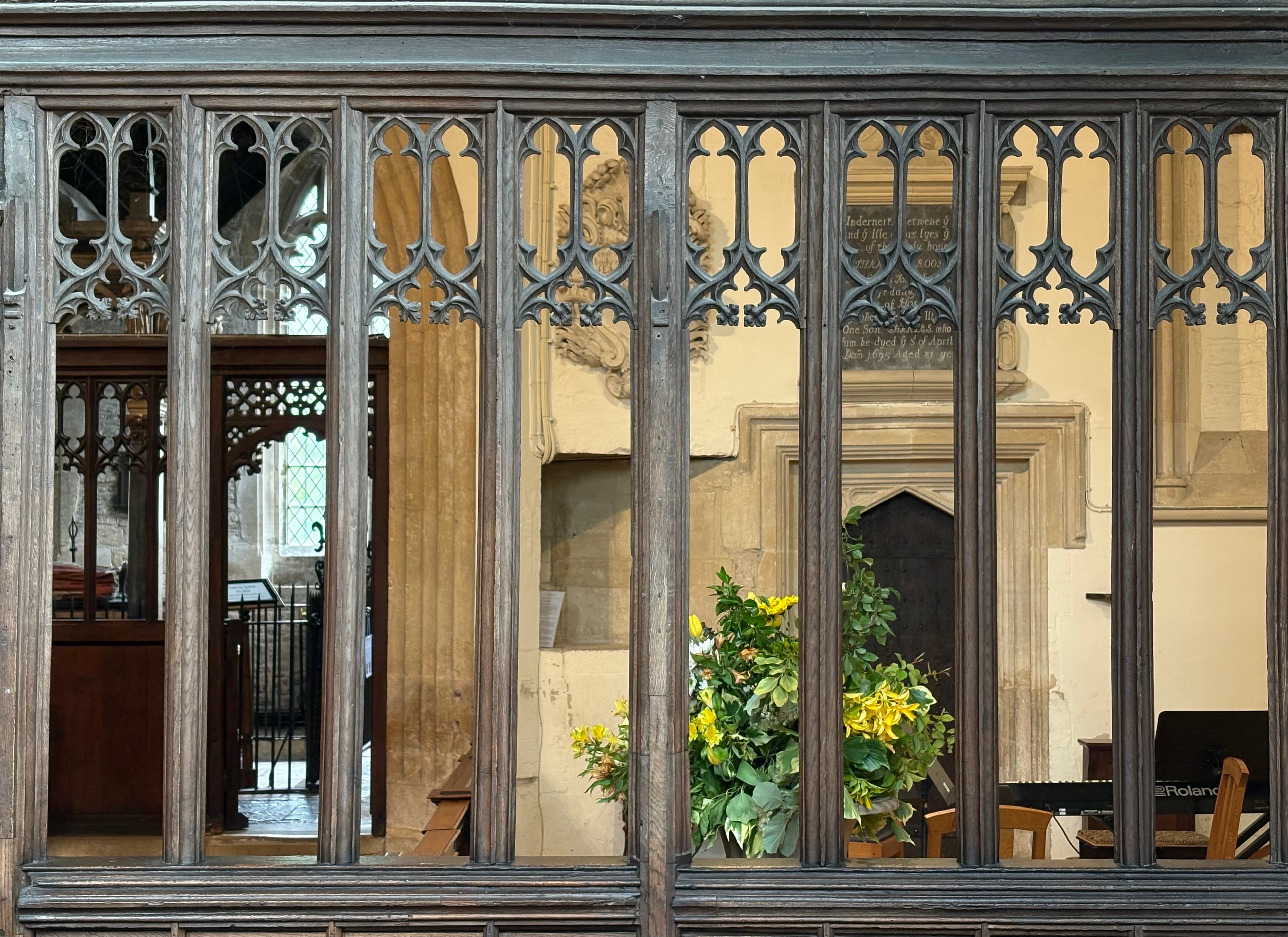 Looking through the screen into a side chapel with floral arrangements