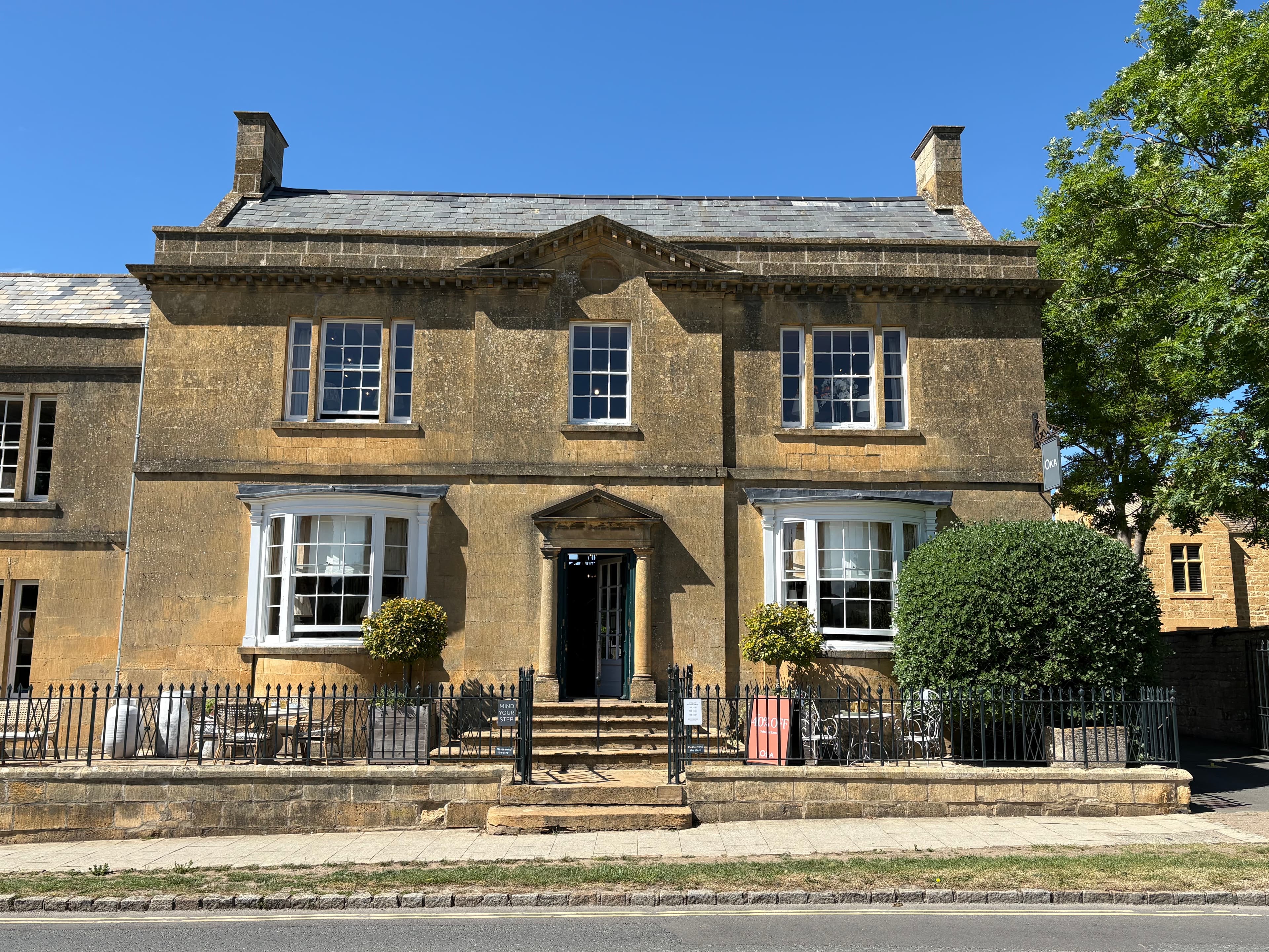 A handsome double-fronted Georgian townhouse in Broadway with sash windows and a pedimented door