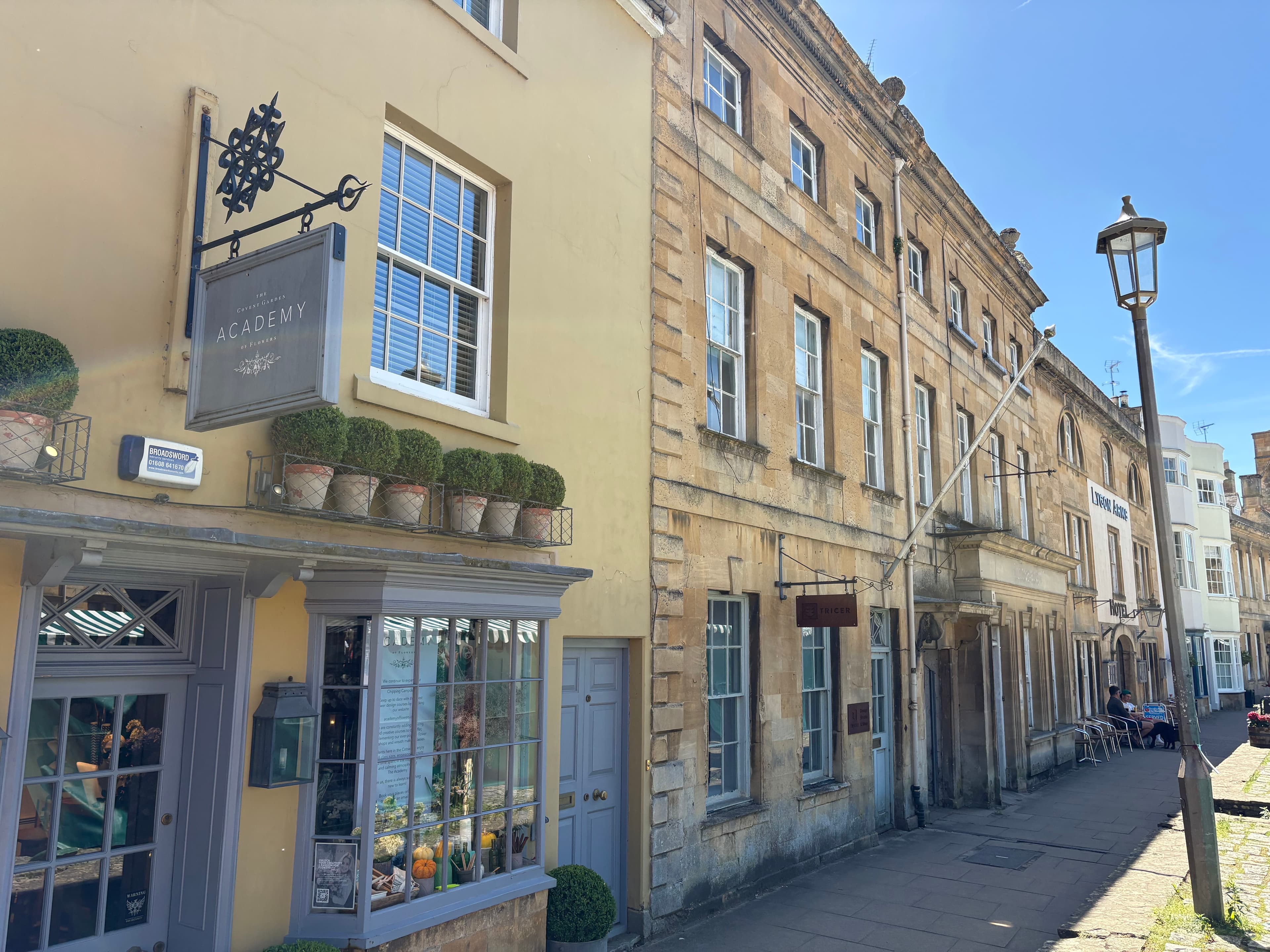 The Academy gallery shopfront on the High Street, with a hanging sign and a row of potted box on the windowsill