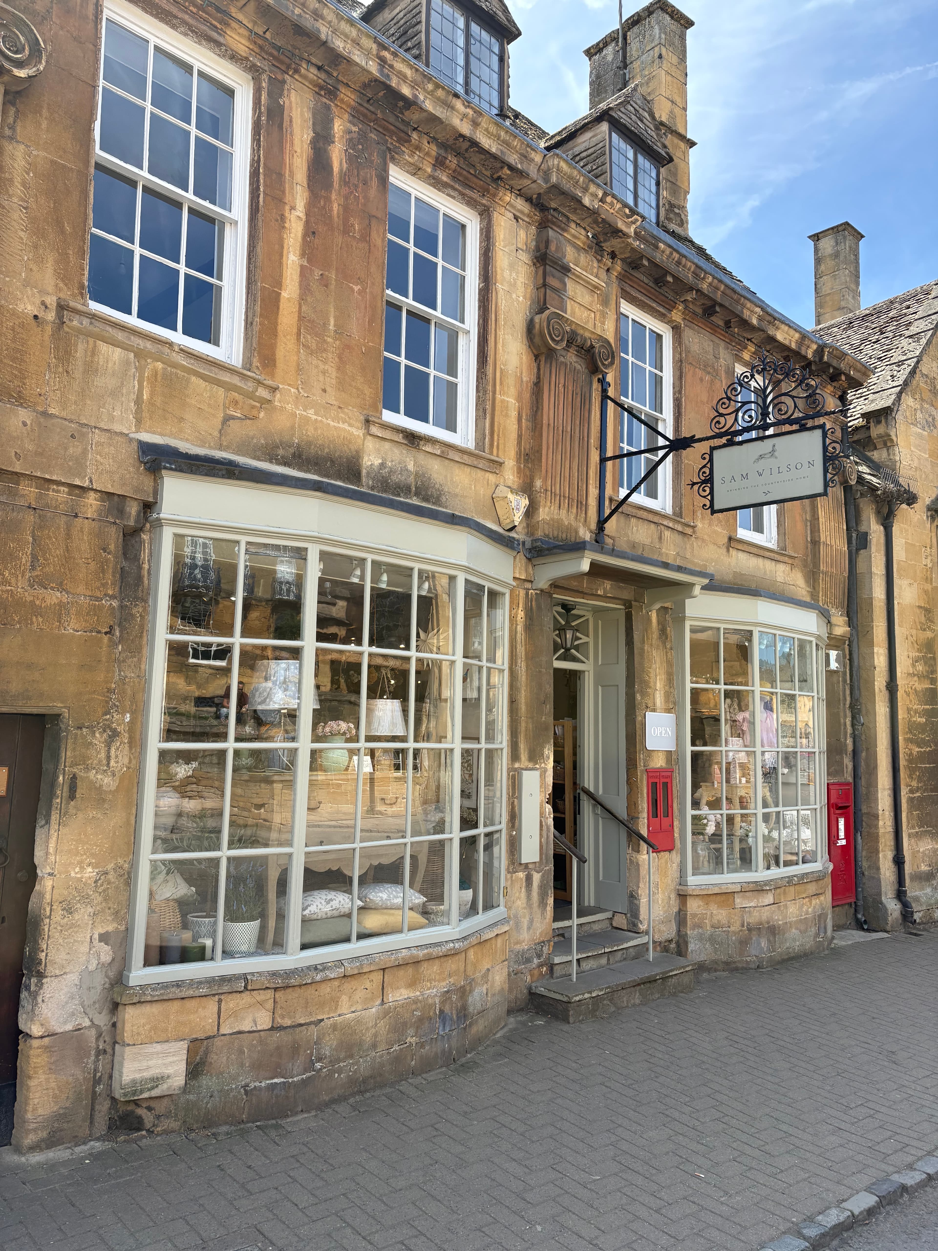 A timber-framed building on the High Street with leaded shopfront windows and a wrought-iron sign bracket