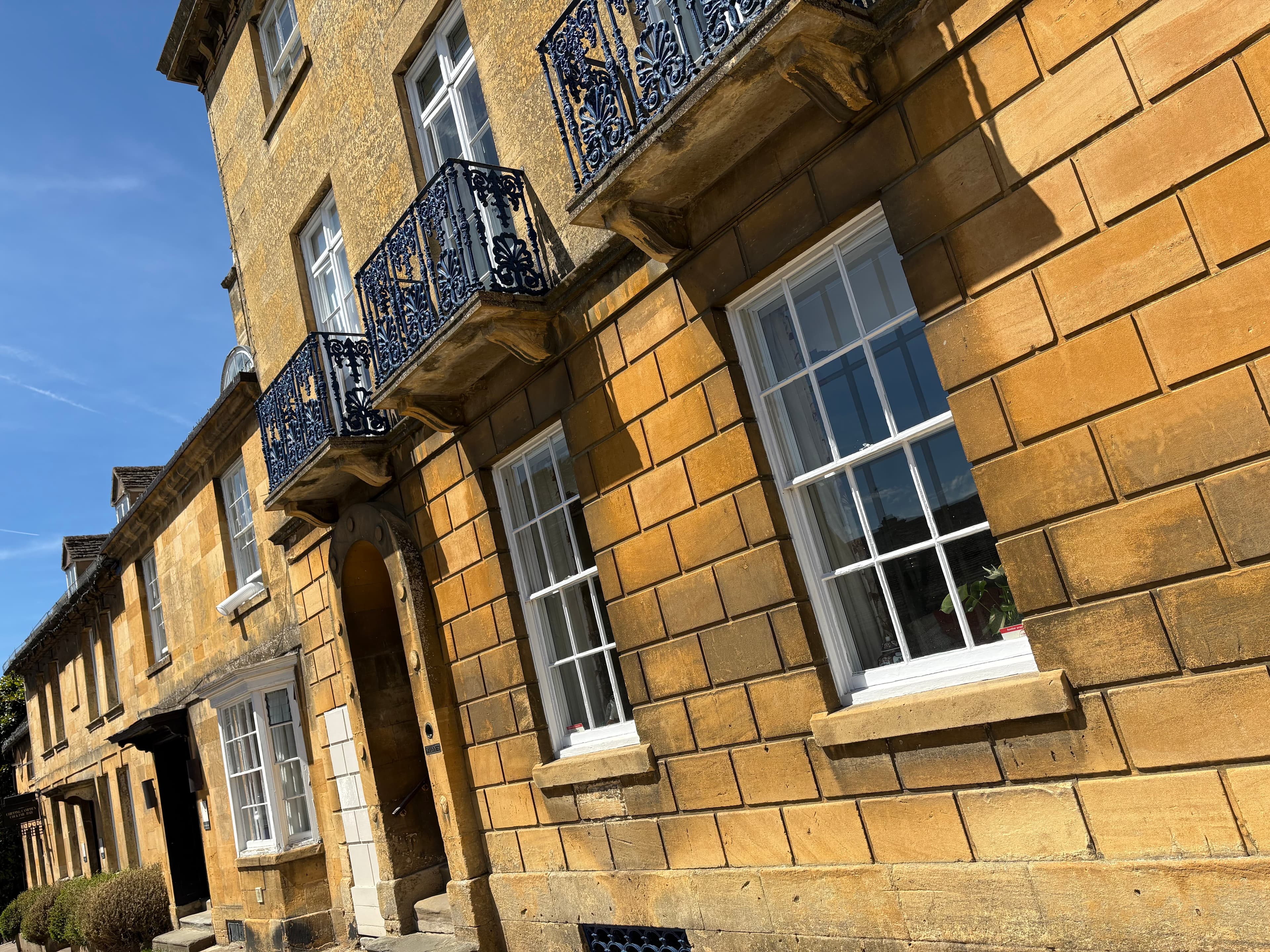 A Georgian townhouse with sash windows, ornate wrought-iron balconies and arched front door