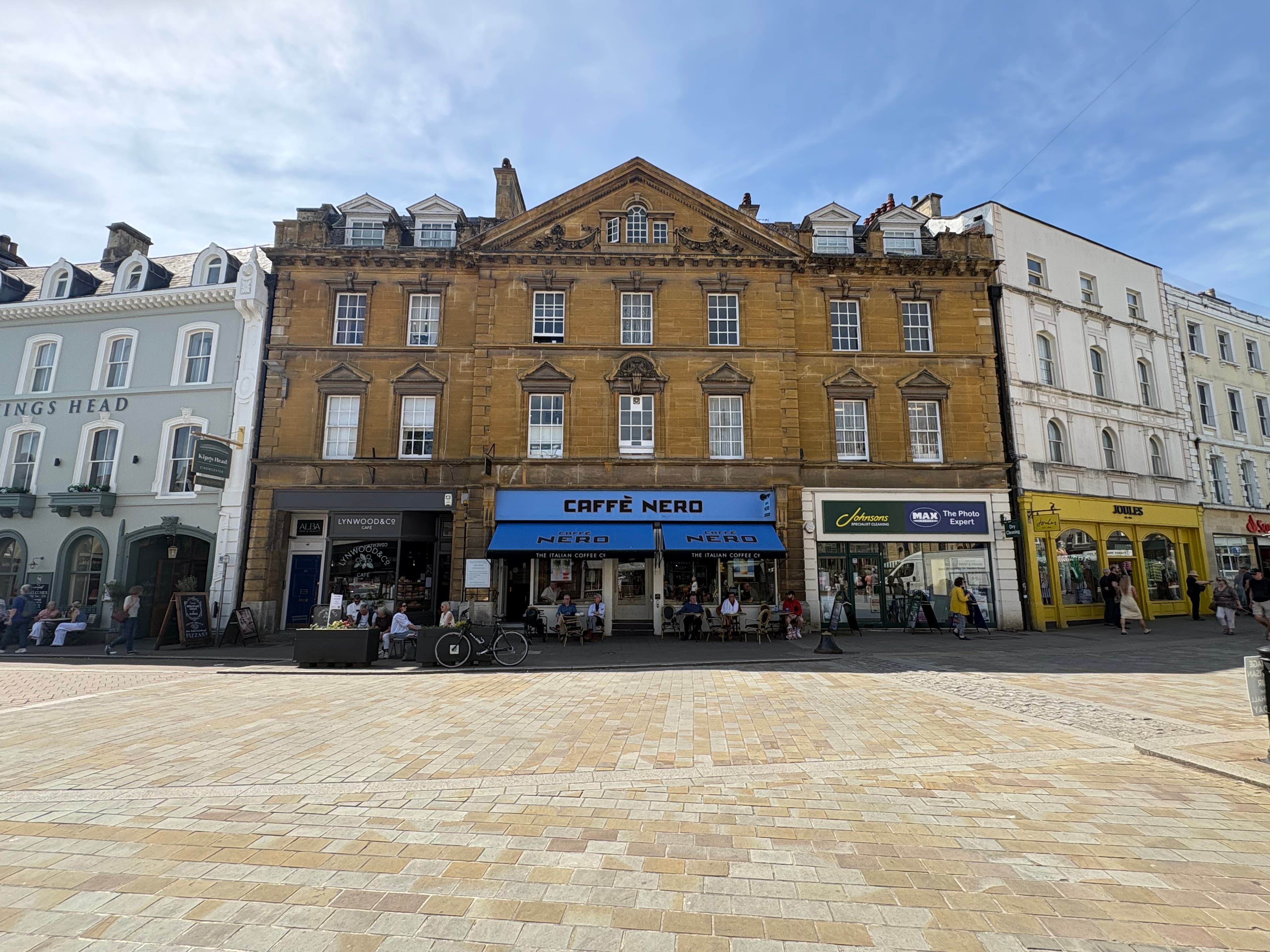 A Cotswold-stone Georgian terrace on the Market Place with a Caffè Nero on the ground floor