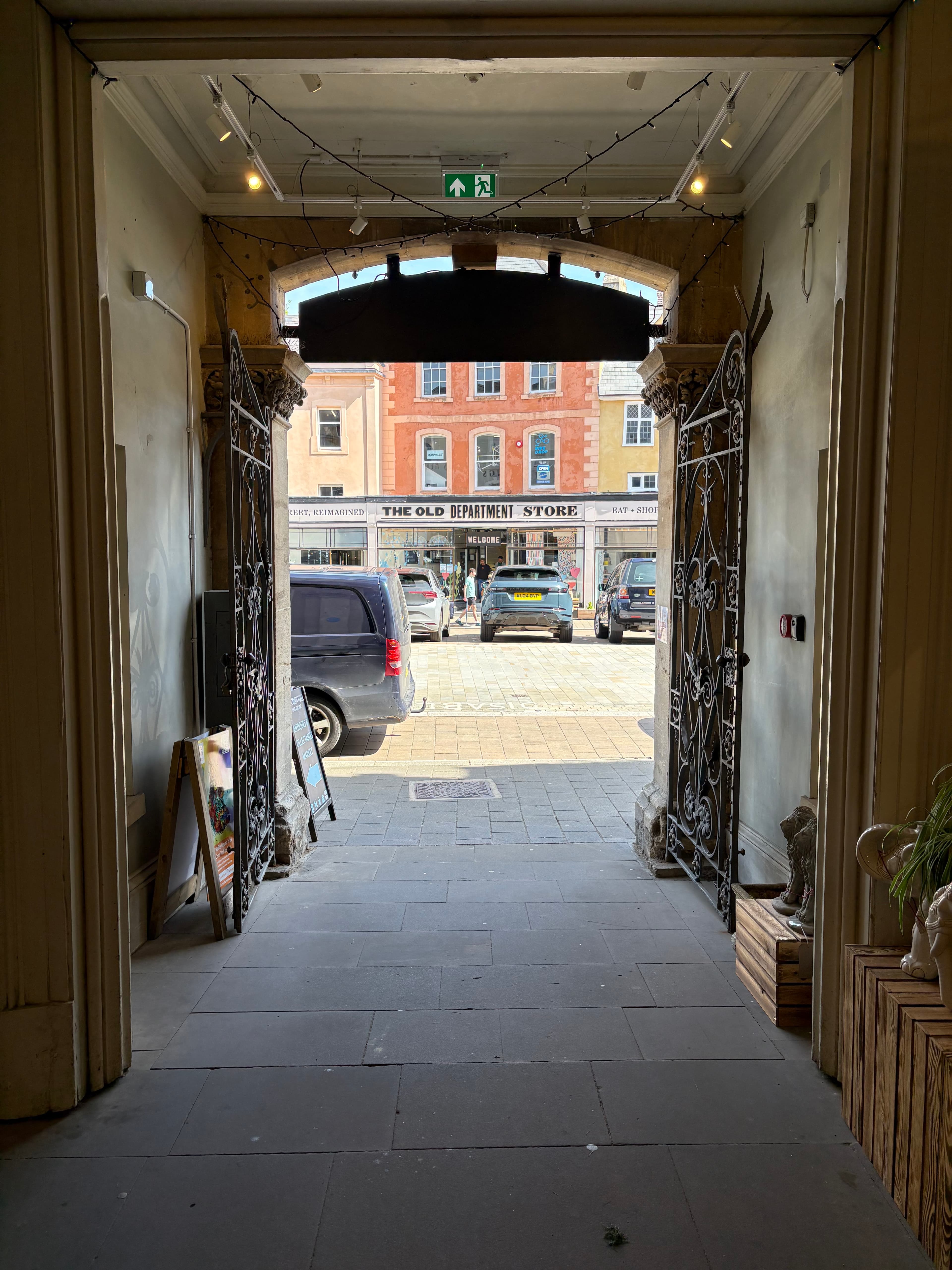 Looking out through an old wrought-iron doorway towards The Old Department Store across the street