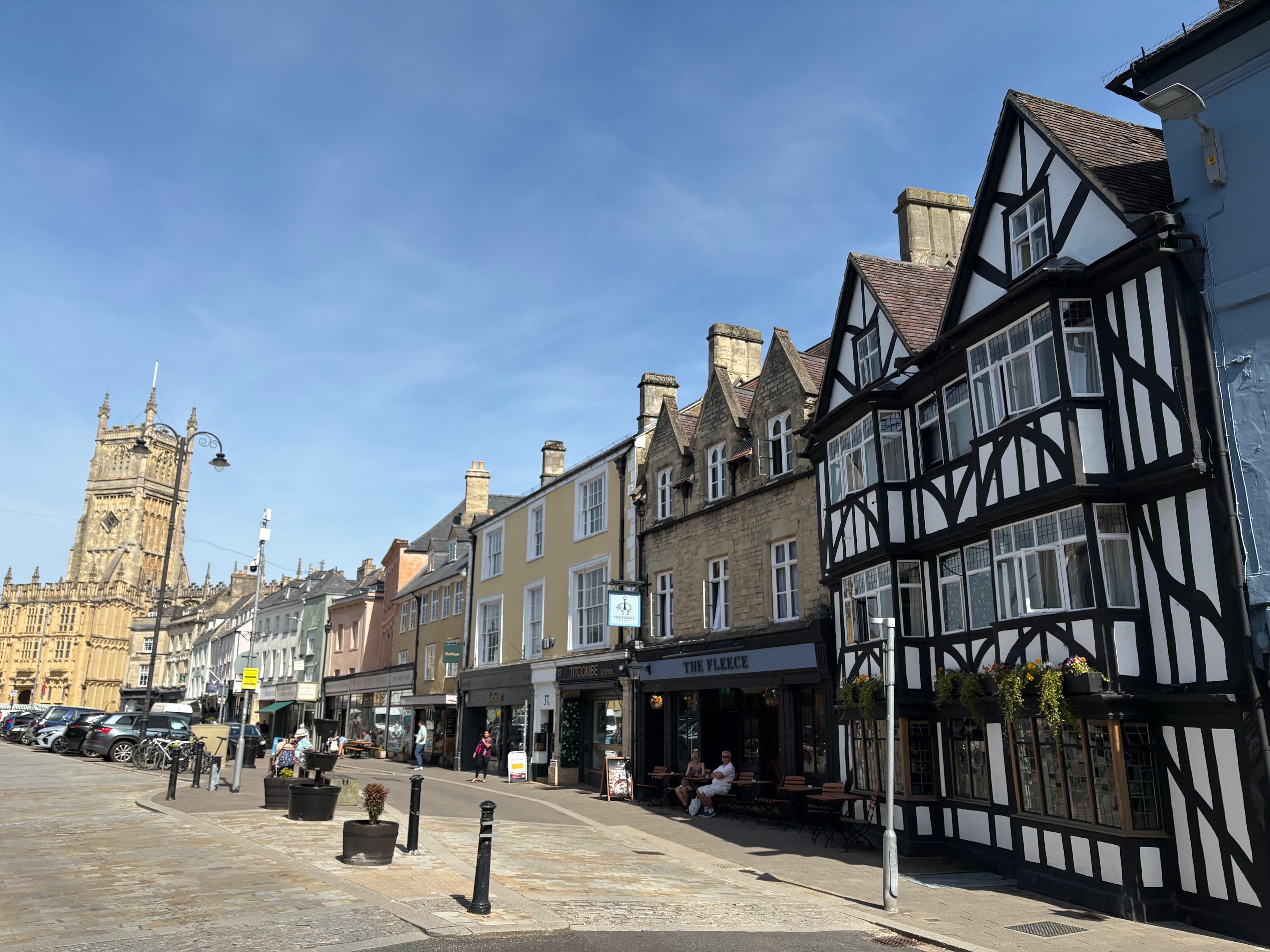 Cirencester Market Place — the half-timbered Fleece Inn on the right, the church tower of St John the Baptist on the left